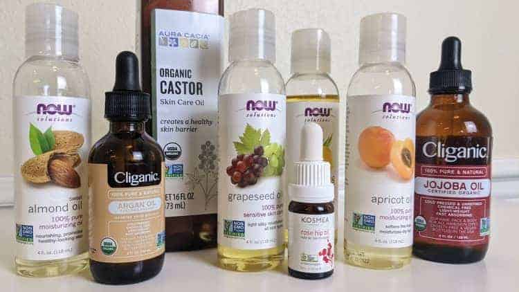what to mix with rosehip oil - bottles of carrier oils (almond, jojoba, castor, grapeseed, apricot, evening primrose) on table