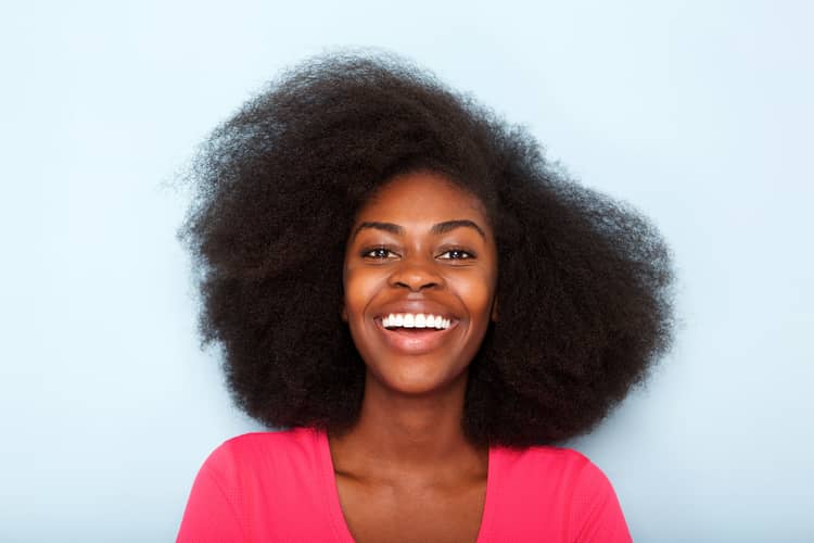 smiling woman with healthy 4C hair